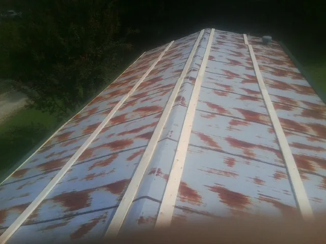 Rusted metal roof panels with new wood purlins before replacement — Storm Damage Roof Repair in Spruce Creek by Roofing Brothers