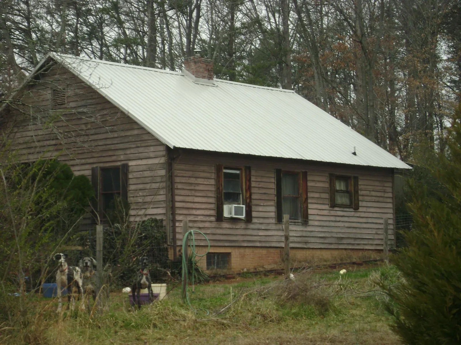 White metal roof on an old wood sided farmhouse, from a Metal Roof Installation job in Spruce Creek